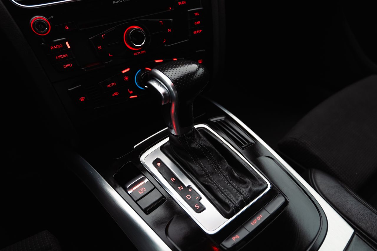 Services Close-up shot of a modern car gear shift lever and control panel, highlighting details.